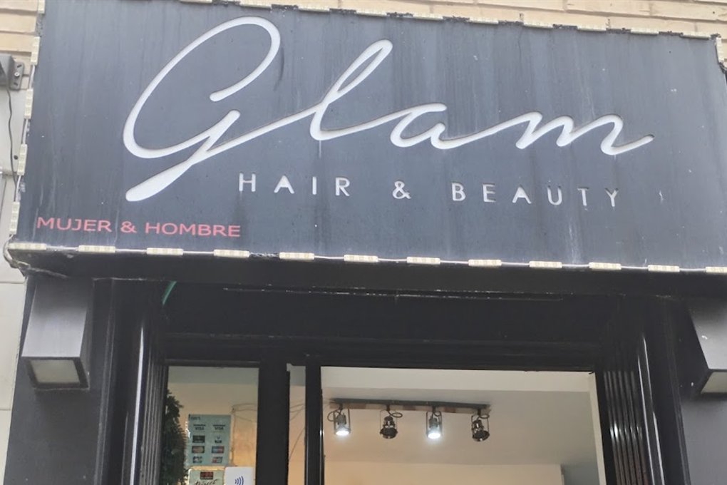 Rótulo negro de la peluquería con el nombre Glam en letra blanca y las palabras Hair & Beauty, Mujer & Hombre