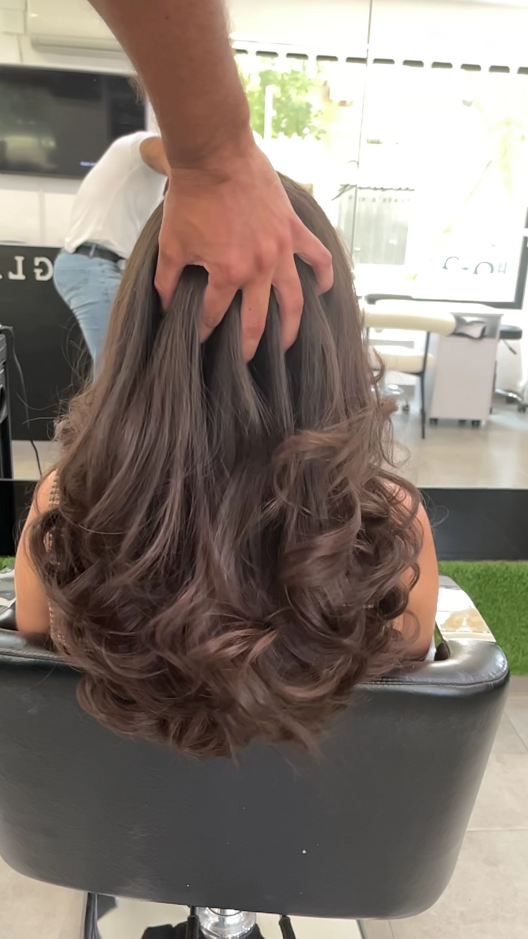 Melena castaña con ondas y volumen, vista de espaldas en el sillón