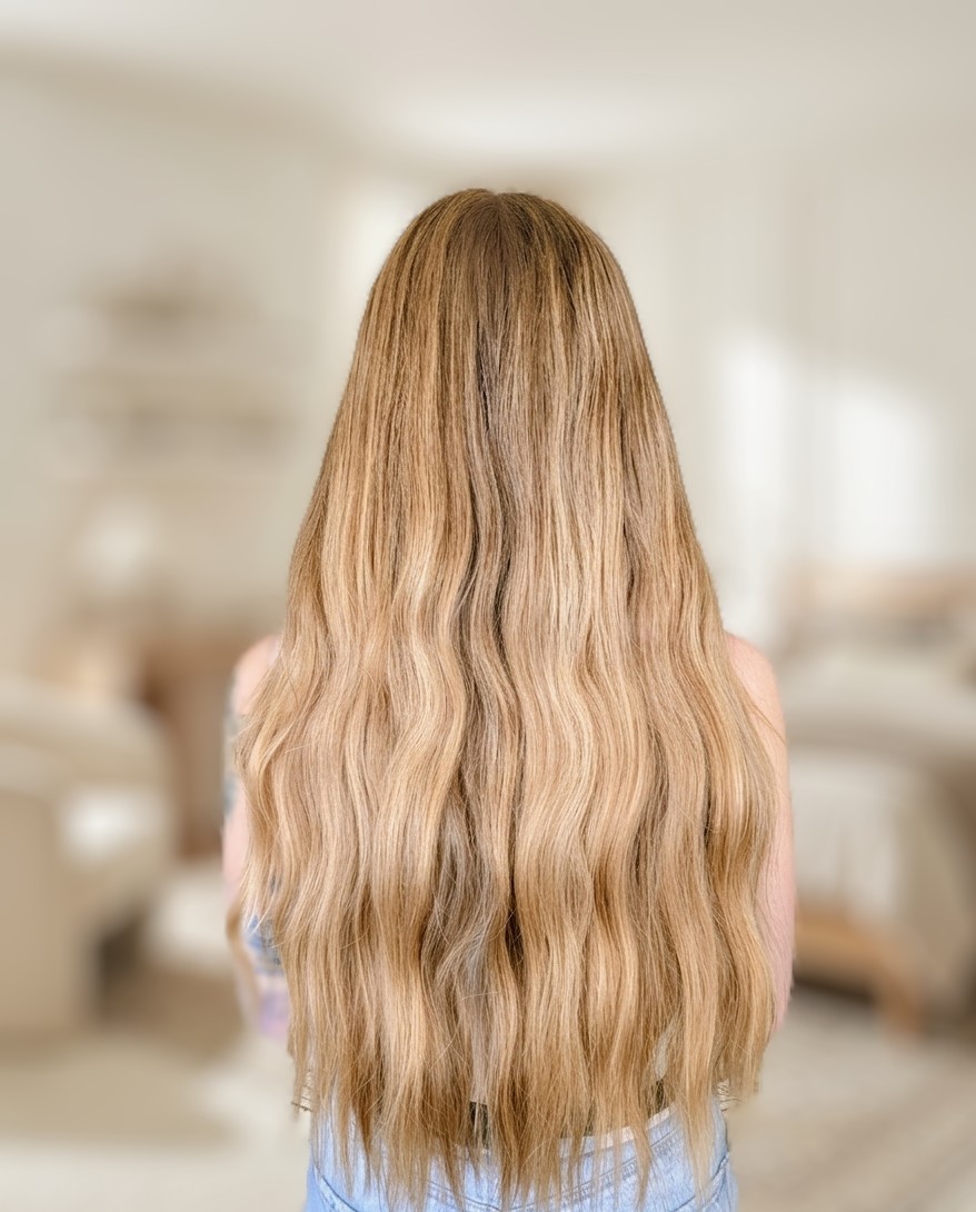 Melena larga rubia con mechas y ondas suaves, vista de espaldas