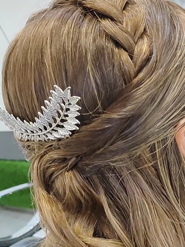 Semirrecogido con trenza y peineta plateada sobre melena con ondas